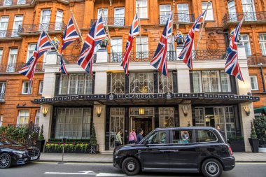 Londra, İngiltere - 14 Eylül 2023: Londra 'nın Mayfair kentinde 5 yıldızlı lüks bir otel ve önünde siyah bir Londra taksisi var..