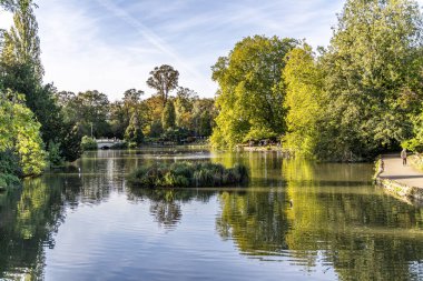 Cheltenham, İngiltere - 15 Ekim 2023: Pittville Park göleti eski köprü ve Regency Spa Cheltenham 'da martıları besleyen insanlar.