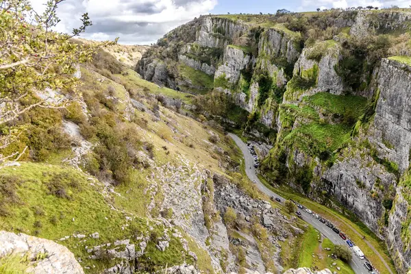 View from cliffs edge of winding road cars Cheddar Gorge in Somerset.
