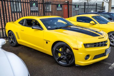 Cardiff , UK - March 3, 2024: Real Size Yellow Chevrolet Camaro Car or Bumblebee Robot in Transformer Movie. clipart