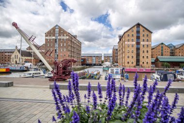 Gloucester, UK- 19 Ağustos 2023: Sharpness Kanalı 'ndaki Gloucester Limanı. Rıhtımda on beş Viktorya dönemi deposu var. Britanya ve Albert Deposu önünde vinçle