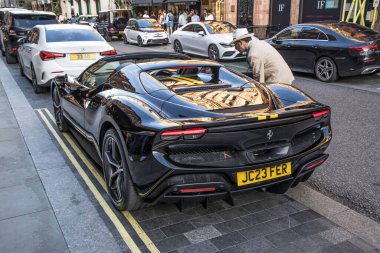 Londra, UK- 19 Ağustos 2023: Ferrari 296 Gtb arka siyah, sarı çizgili Mayfair Mount Caddesi 'nde park edilmiş..