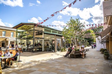 London, UK- August 19, 2023: Duke of York Square with shops Monica Vinader and people and British Union Jack flags. clipart