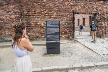 Auschwitz, Poland- 16 Temmuz 2023: Auschwitz toplama kampındaki İnfaz Duvarı 'na giriş ve mesaj panosu.