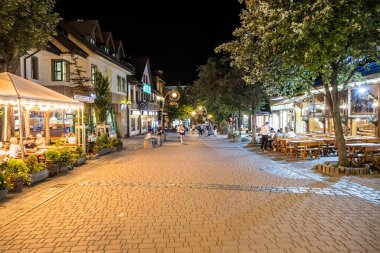 Zakopane, Poland- 16 Temmuz 2023: gece vakti Zakopane 'de ünlü Krupowki caddesi. Krupowki caddesi, merkezdeki ana alışveriş alanı ve yaya geçidi..