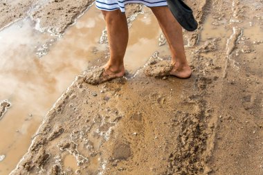 Çamurlu suda kadınların ayakları.