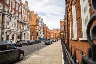Londra, İngiltere - 14 Eylül 2023: Kensington 'da güzel periyodik binalarla sokak manzarası. Mayfair lüks bir yaşam tarzıyla yaşamak için en zengin yerlerden biri..