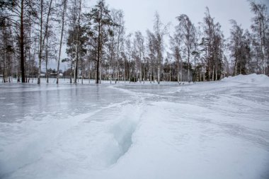 Kış sahnesinde, kar kaplı yüzeyde donmuş buzlar vardı. Karda siyah buz. Kaygan yüzey.