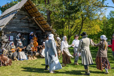 Riga, Letonya - 23 Haziran 2024: Geleneksel kostümlü Letonya halk dansları. Letonya yazı. Ligo tatili için Letonya 'nın sembolü. Letonya 'da yaz ortası.