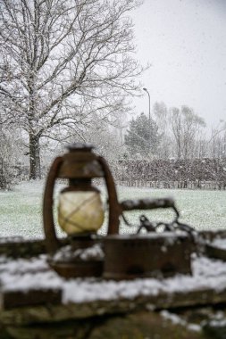 Selective focus on heavy snow fall old lamp and coal iron in front. clipart