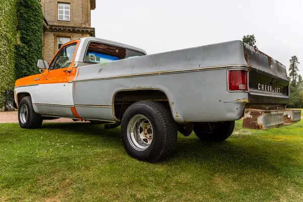 Bristol, UK- 11 Ağustos 2024: 1970 'lerin klasik Chevrolet Cheyenne 10 kamyonetinin turuncu ve beyaz gövdeli arka tarafı. Ağda ve cilalama. Güzelce restore edilmiş. Koleksiyon klasiği.