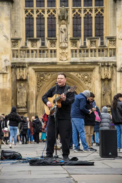 Stock image Bath, UK - June 5 2023: Street musician with guitar in front of Bath Abbey.