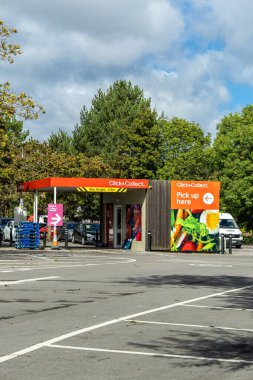 Bristol, UK - September 12, 2024: Tesco supermarket Click and Collect pickup area at a retail store, with a clear sign directing customers to the collection point. clipart