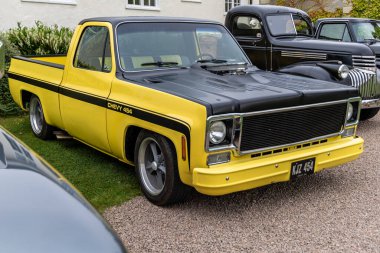 Bristol, UK- 11 Ağustos 2024: Sarı 1973 Chevrolet C K kamyonet klasik bir Amerikan kaslı arabasıdır. CHEVY 454.