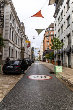 Hamburg, Almanya - 17 Haziran 2024: Pahalı dükkanlar, yürüyen insanlar ve mimari yapı cepheleriyle merkez alışveriş caddesi Neuer Wall 'un manzarası.