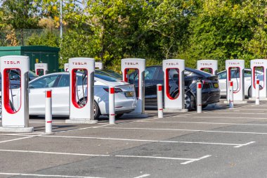 Londra, UK- 19 Eylül 2024: Bir süperşarj istasyonunda çalışan Tesla arabaları sırası.