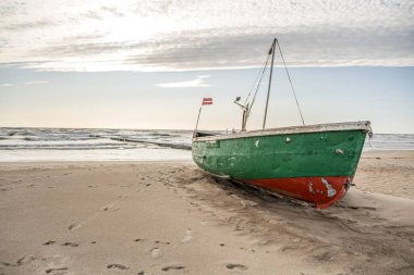 Baltık Denizi kıyısında terk edilmiş eski yeşil ahşap bir tekne..