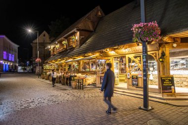 Zakopane, Poland- 16 Temmuz 2023: gece vakti Zakopane 'de ünlü Krupowki caddesi. Krupowki caddesi, merkezdeki ana alışveriş alanı ve yaya geçidi..
