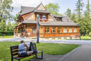 Zakopane, Poland- 16 Temmuz 2023: Sanatçı dağ tarzında eski ahşap ev çiziyor.