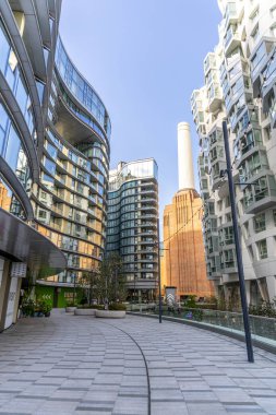 Londra, modern apartman cephesi. Uzakta Battersea Elektrik Santrali bacaları olan eğimli pencereleri var..