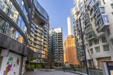 Londra, modern apartman cephesi. Uzakta Battersea Elektrik Santrali bacaları olan eğimli pencereleri var..