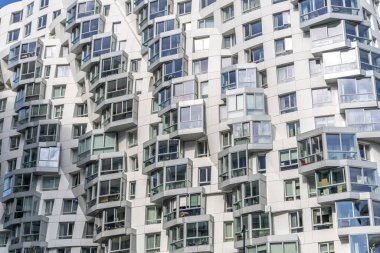 Londra, eğimli pencereli modern apartman cephesi.