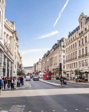Londra, UK- 19 Eylül 2024: Londra Klasik Mimarisi Modern Yaşamla Tanışıyor: Meşgul Şehir Sokağı İkonik Kırmızı Otobüs ile.