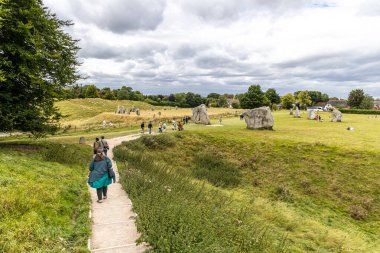 Avebury, UK- 25 Ağustos 2024: Tarih öncesi Avebury Stone Circle, Wiltshire, İngiltere, İngiltere 'deki Stones yakınlarında yürüyen insanlar.