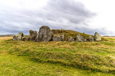 Outside stones of the West Kennet Long Barrow ancient monument burial chamber near Avebury in Wiltshire, England. clipart