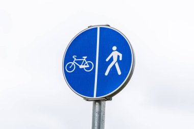 Bisiklet ve yayaların yolu gri gökyüzüne izole edilmiş. Bisiklet ve yürüyüş yolu işareti.