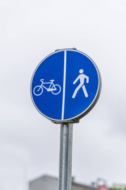 Bisiklet ve yayaların yolu gri gökyüzüne izole edilmiş. Bisiklet ve yürüyüş yolu işareti.