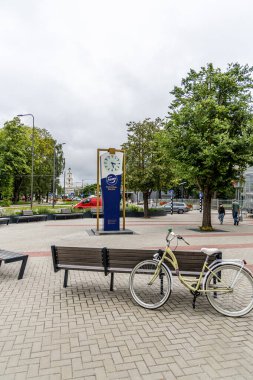 Liepaja, Letonya - 12 Haziran 2024: Fazer saati ve Liela caddesi ve eski şehir merkezindeki tramvay manzarası.