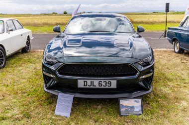 Llandow, Wales - June 30, 2024: Front of 2020 Ford Mustang Bullit in dark green color. clipart