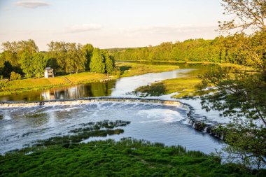 Avrupa 'nın en geniş şelalesi olan Kuldiga' daki Venta Rapid şelalesi Ventas rumba, Letonya 'nın doğal bir anıtı olarak gösterildi..