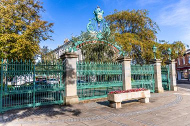 Cheltenham, UK - October 15, 2023: Pittville Park entrance gates with flower. Pittville Gates were built in 1833 as an elegant entrance to the Estate. clipart