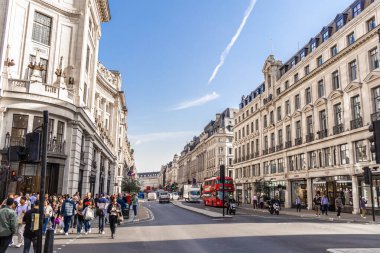 Londra, UK- 19 Eylül 2024: Londra Klasik Mimarisi Modern Yaşamla Tanışıyor: Meşgul Şehir Sokağı İkonik Kırmızı Otobüs ile.