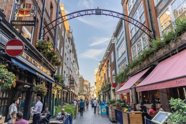 Londra, UK- 19 Eylül 2024: Londra 'nın merkezindeki Vibrant Carnaby Caddesi, dükkanlar, turistler ve yerel cazibeyle ziyaret edilmesi gereken bir moda merkezi..