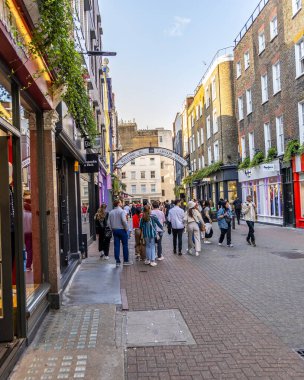 Londra, UK- 19 Eylül 2024: Londra 'nın Soho' sundaki Carnaby Caddesi 'ndeki Bustling Carnaby Caddesi, renkli dükkanlar ve turist ve yerel halkla dolu ikonik moda merkezi.