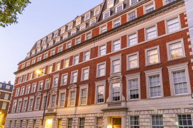 Londra, UK- 19 Eylül 2024: Londra 'daki Dusk Windows Aglow' da Şık Tuğla Bina, İngiliz Mimari Mirasını Gösterme.