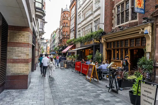 Londra, UK- 19 Eylül 2024: Antika Tuğla Binaları ve Kafe Kültürü ile Tarihi Soho Sokağı Sahnesi.