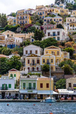 Symi, Yunanistan - 10 Mayıs 2024: Suriye adasındaki renkli evler köyü, Dodecanese Adası, Yunanistan.