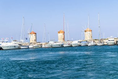 Rhodes, Greece - May 9, 2024: Windmills at the seafront in the city of Rhodes in Rhodes island. clipart