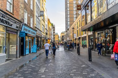 Londra, UK- 19 Eylül 2024: Londra 'da kaldırımlı yolu, dükkanları ve yürüyen insanları olan SCharming Soho Caddesi.
