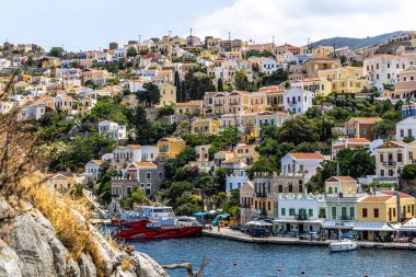 Symi, Yunanistan - 10 Mayıs 2024: Suriye adasındaki renkli evler köyü, Dodecanese Adası, Yunanistan.