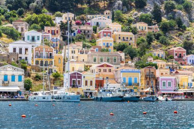 Symi, Yunanistan - 10 Mayıs 2024: Suriye adasındaki renkli evler köyü, Dodecanese Adası, Yunanistan.