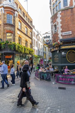 Londra, UK- 19 Eylül 2024: Soho Tarihi Şehir Sokakları Yayalar ve Açık Cafeler ve barlar Güneşli bir günde.