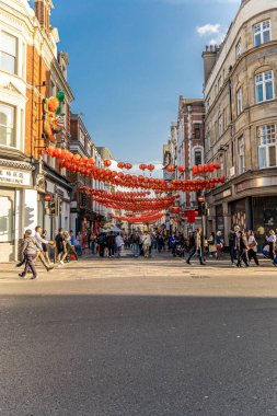 Londra, UK- 19 Eylül 2024: Çin Mahallesi 'nde kalabalık bir caddede asılı duran kırmızı fenerler, insanlarla ve şehir hayatıyla dolu..