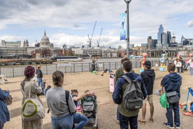 Londra, UK- 6 Ağustos 2023: Queens Walk gezinti güvertesinde sokak sanatçıları. Thames Nehri Southbank yolundan Westminster Köprüsü 'nden Tower Köprüsü' ne kadar turistler ve ziyaretçiler için gezi.
