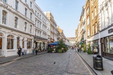 Londra, UK- 19 Eylül 2024: Kafeler, tarihi binalar ve alışverişçiler ile canlı Londra alışveriş bölgesi.