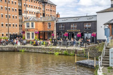 Gloucester, UK- 19 Ağustos 2023: Gloucester Rıhtım Keskinlik Kanalı 'ndaki Wetherspoon Bar. Rıhtımda on beş Viktorya dönemi deposu bulunuyor..